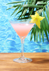 Glass of cocktail on blue sea background