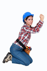 Female building worker kneeling on white background