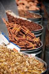 selection of cinnamon and spices on market stall 