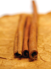 Festive wrapped cinnamon sticks on the white background