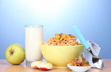 tasty cornflakes in green bowl, apples and glass of milk