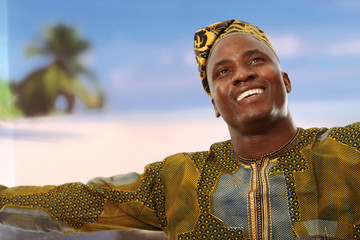 A smiling black man on the beach is looking upwards