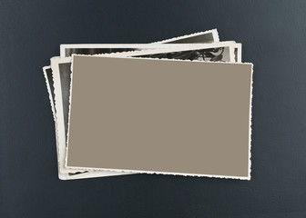 Stack of old photos on elegant, black leather