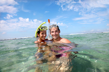 Portrait of happy couple doing snorkeling - obrazy, fototapety, plakaty
