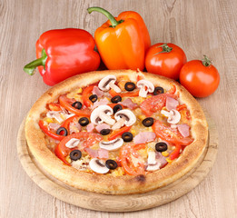Aromatic pizza with vegetables on wooden background