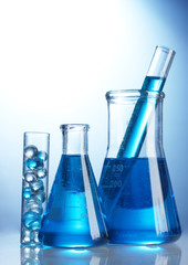 Test-tubes with blue liquid on blue background