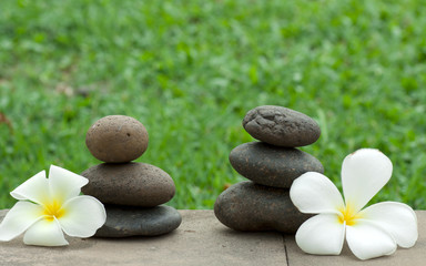 Fototapeta na wymiar Brown flat stones in blance with frangipani flowers