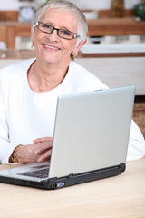 Young man helping senior woman buy online