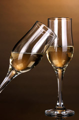 Glasses of champagne on brown background