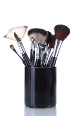 make-up brushes in black cup isolated on white