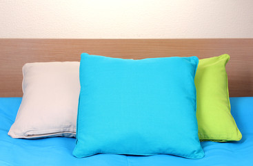 bright pillows on bed on beige background