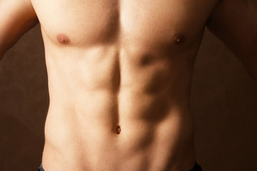 Naklejka premium Muscular man , isolated on brown background