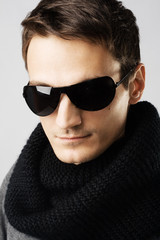 Handsome man in dark sunglasses and black scarf