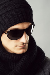 Stylish handsome man in dark sunglasses and black clothing