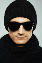 Stylish handsome man in dark sunglasses and black clothing