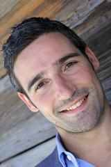 Portrait of businessman standing in front of wooden wall