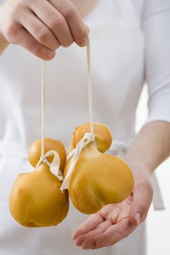 Woman holding two Provolone cheeses