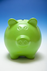 Piggy bank or money box on a graduated blue studio background.