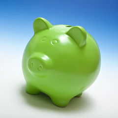 Piggy bank or money box on a graduated blue studio background.