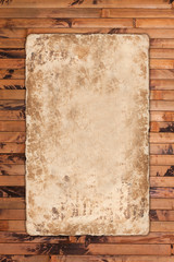 Aged grungy paper sheet on a wooden background