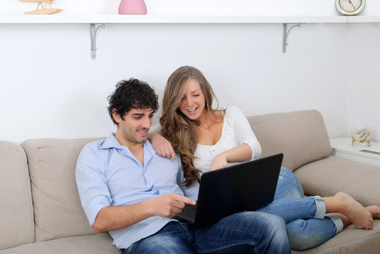Young couple watching something on a laptop