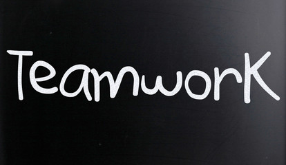 The word "Teamwork" handwritten with white chalk on a blackboard
