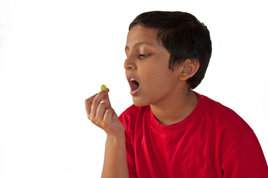 Asian,Indian,Bengali Young Boy Eating Grape,open Mouth,isolated