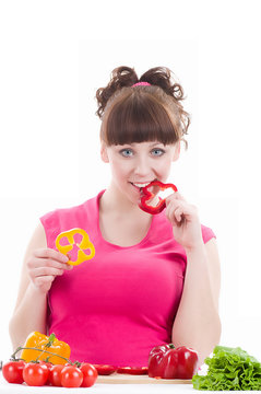 Beautiful young girl with pepper on white background.