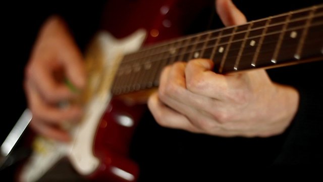 Male hands play on electric guitar