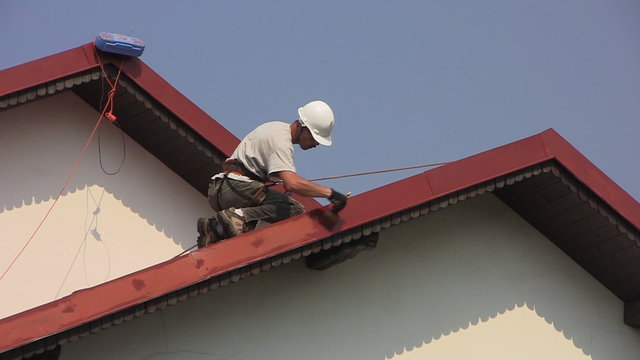 Man paints roof of a private house