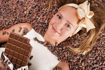 beautiful girl with chocolate on cocoa beans