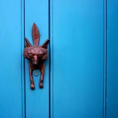 Blue door with an ornate fox face door knocker