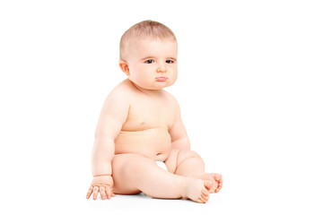A 9 month old baby in diapers sitting