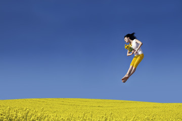 Happy Woman jumping with flower