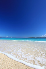 打ち寄せる透明な波と紺碧の空