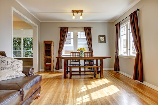 Dining room with brown curtain and hardwood floor.