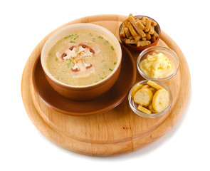 Tasty soup on wooden round board isolated on white