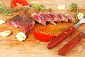 roasted lamb meat fillet ready on wooden board with cutlery