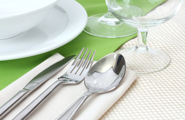 Table setting with fork, knife, spoon, plates, and napkin