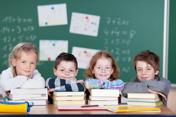 vier grundschüler stützen sich auf bücher