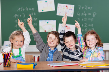 vier schulkinder zeigen auf
