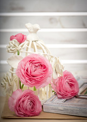 pink ranunculus flowers with decorative bird cage