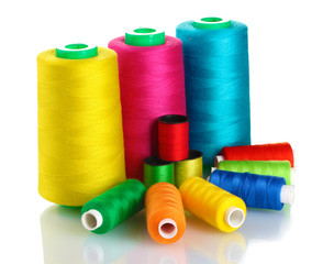 Many-coloured bobbins of thread isolated on white