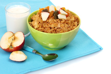 tasty cornflakes in bowl with dried fruits, glass of milk and