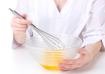 Female hands Mixing eggs in bowl isolated on white