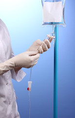 Nurse doing infusion on blue background
