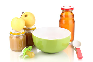 Jars of baby puree with plate and spoon isolated on white