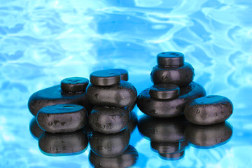 Spa stones with droplets on blue background