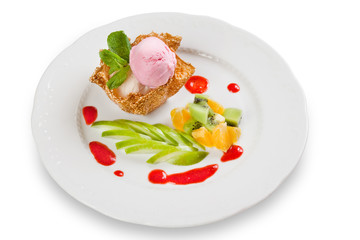 Ice cream in krokant basket with sauce on plate