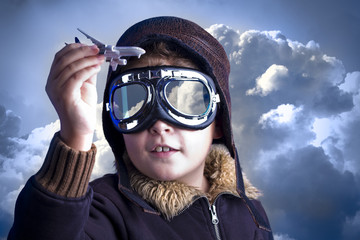 Little boy in the pilot`s hat. Boy as an old style pilot holding